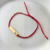 Bransoletka na czerwonym sznurku ze złotą blaszką i stópkami z możliwością graweru z dwóch stron - pr. 585 